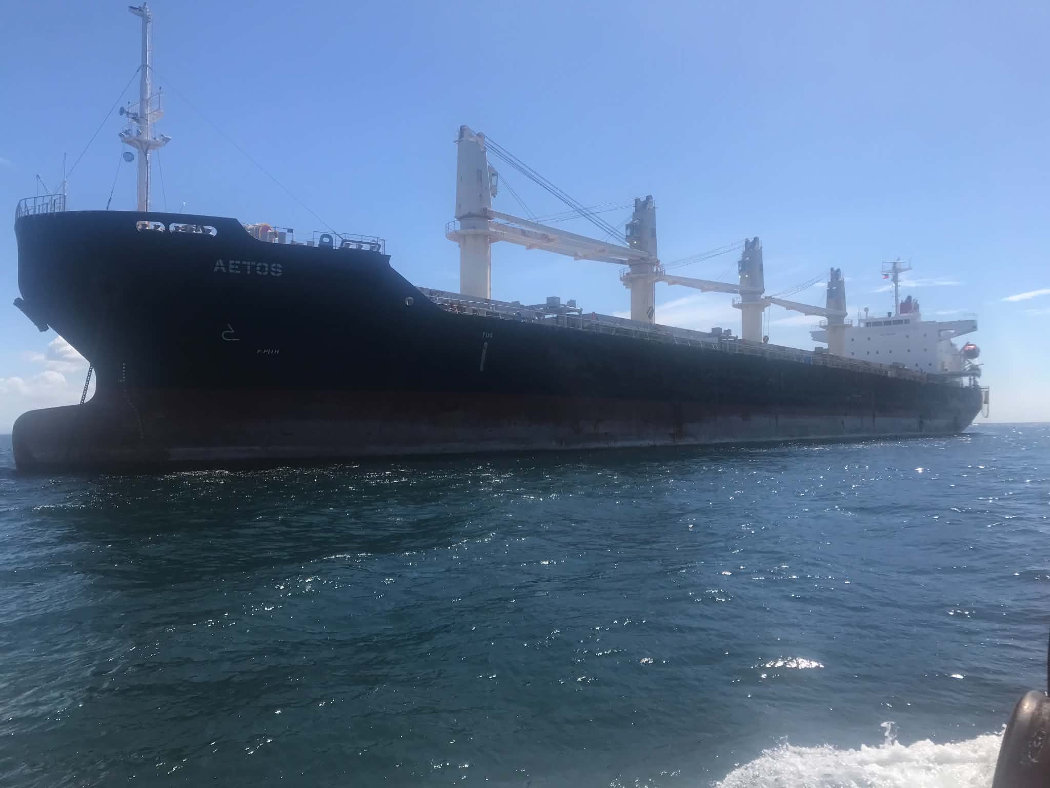 Crew member signaling under a ship's crane